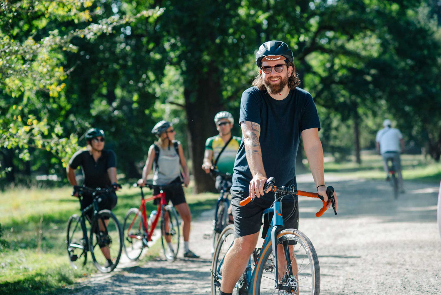 vier junge Menschen mit Gravel Bikes in einem Park