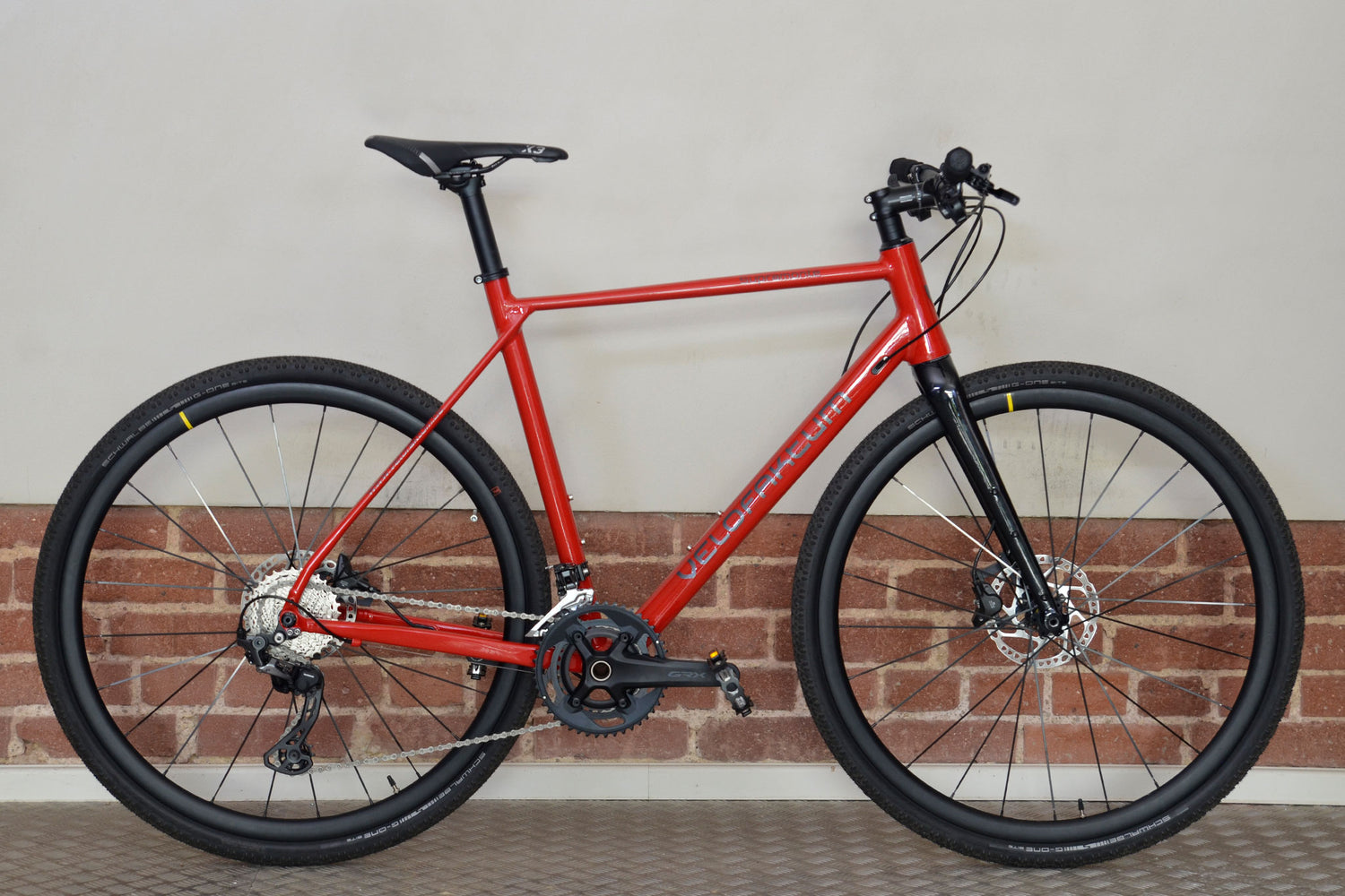 Fahrrad Gravelbike von Velofaktum in rot mit silberner Schrift.